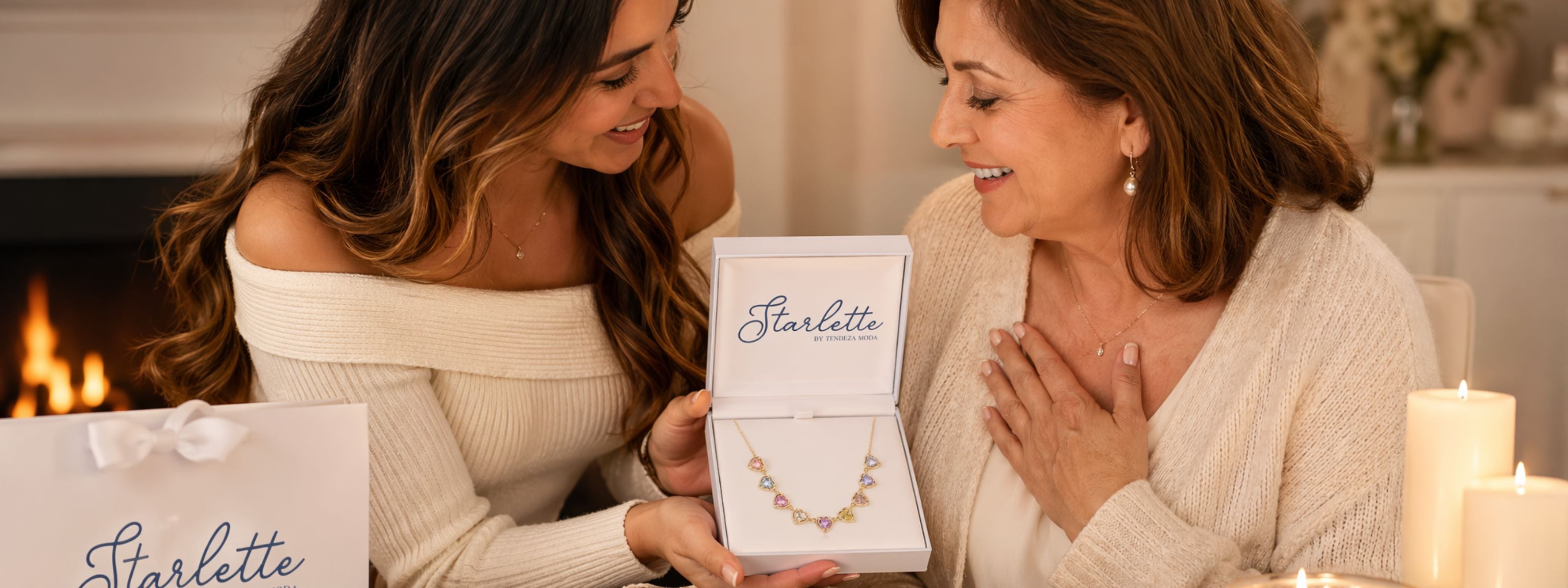 Daughter giving mother a Starlette necklace for Mother's Day, in a warm indoor setting.