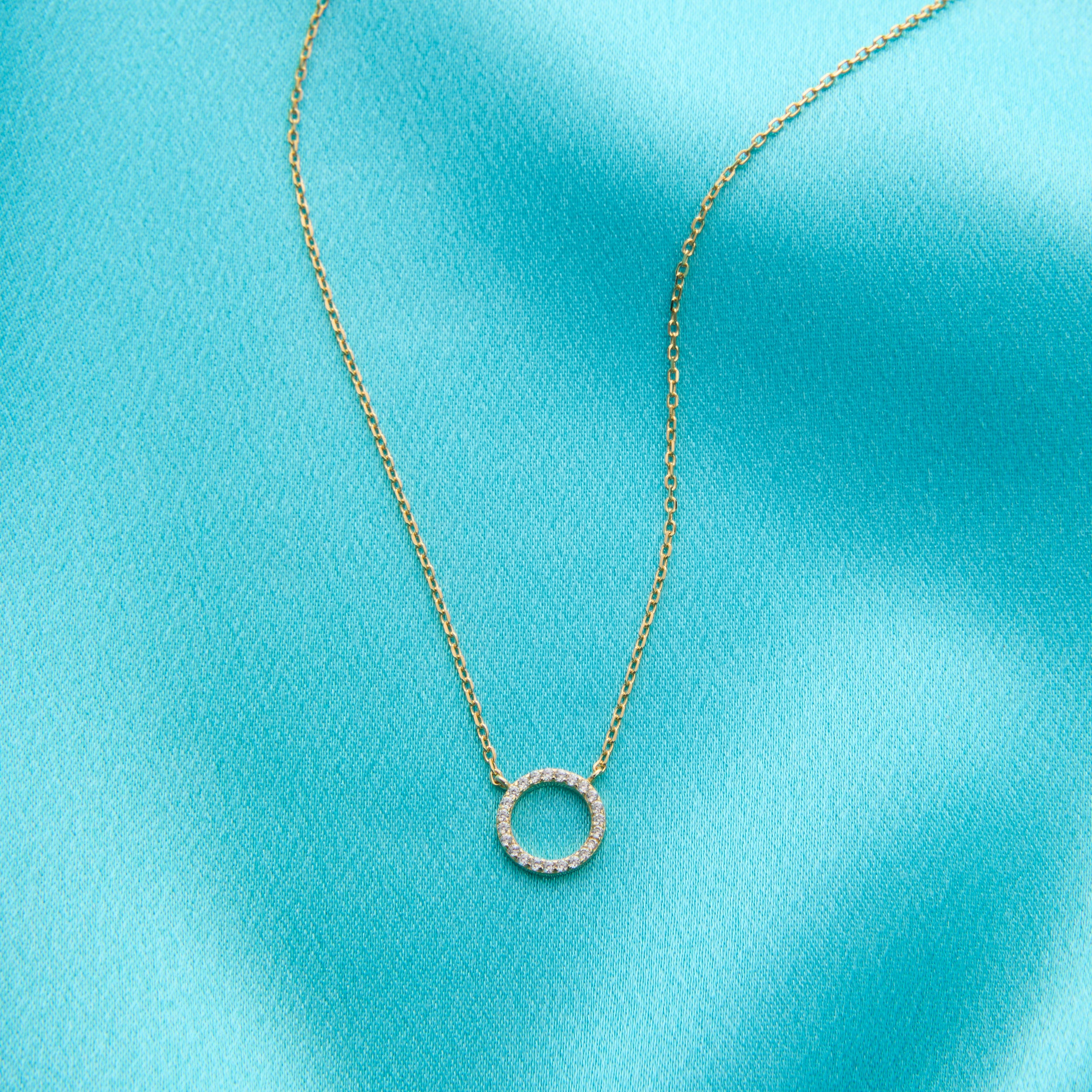 Created with certified 925 sterling silver and
Plated in 14k gold and set in an intricate prong setting
The sparkling stones are 100% simulated diamond material (AAA CZ)
The chain is extendable up to 17", and the circle measures approximately 1/2"