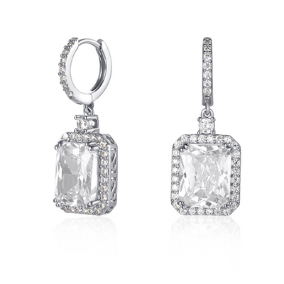 Features a 4-carat emerald cut stone surrounded by a halo of small stones around the main stone
Huggie style earring design
Also available in gold