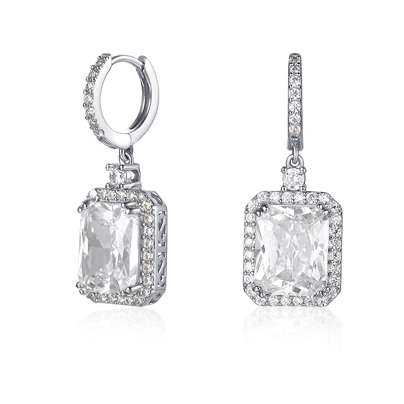 Features a 4-carat emerald cut stone surrounded by a halo of small stones around the main stone
Huggie style earring design
Also available in gold