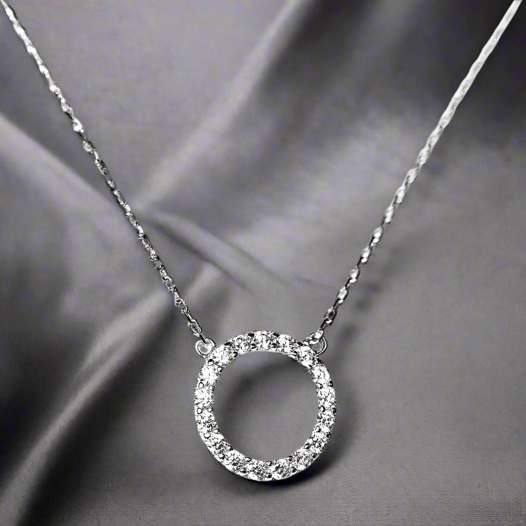 Created with certified 925 sterling silver
Plated in Rhodium and set in an intricate prong setting
The sparkling stones are 100% simulated diamond material (AAA CZ)

The chain is extendable up to 17", and the circle measures approximately 1/2"