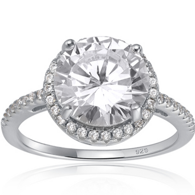 Features a 3-carat round cut center stone
Surrounded by a gorgeous halo set in a prong setting
Set with a pave band, this ring features 45 total stones
Sterling silver with Rhodium plating
Available in gold and sizes 4 through 11