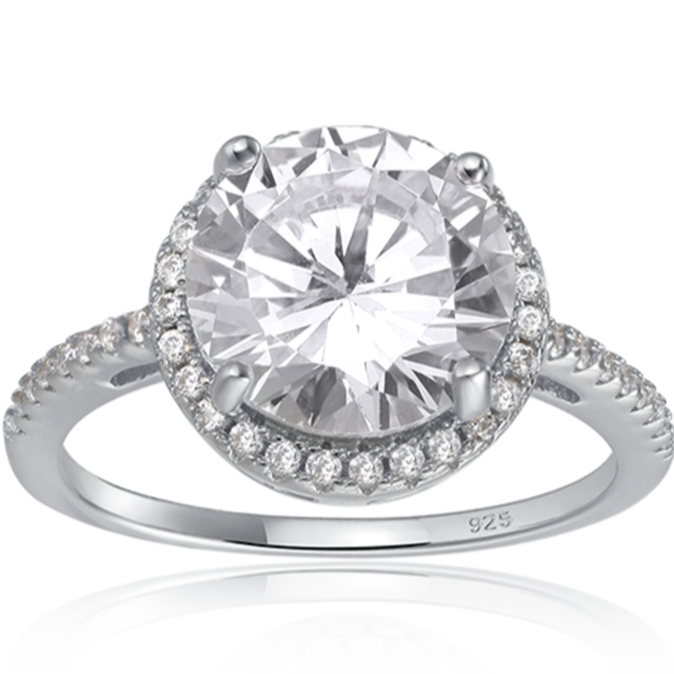 Features a 3-carat round cut center stone
Surrounded by a gorgeous halo set in a prong setting
Set with a pave band, this ring features 45 total stones
Sterling silver with Rhodium plating
Available in gold and sizes 4 through 11